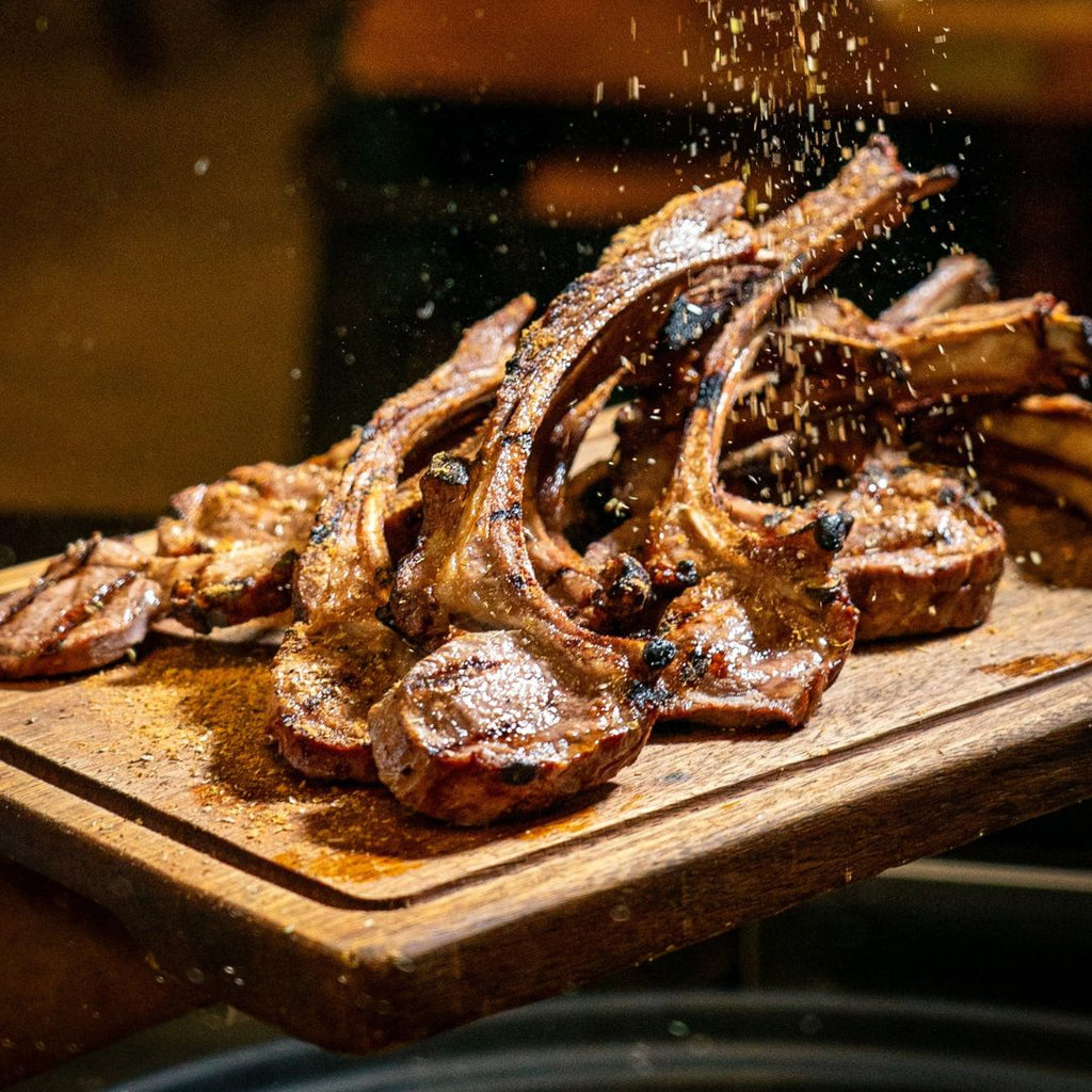 Friptură de oaie presărată cu mirodenii pe fundal rustic