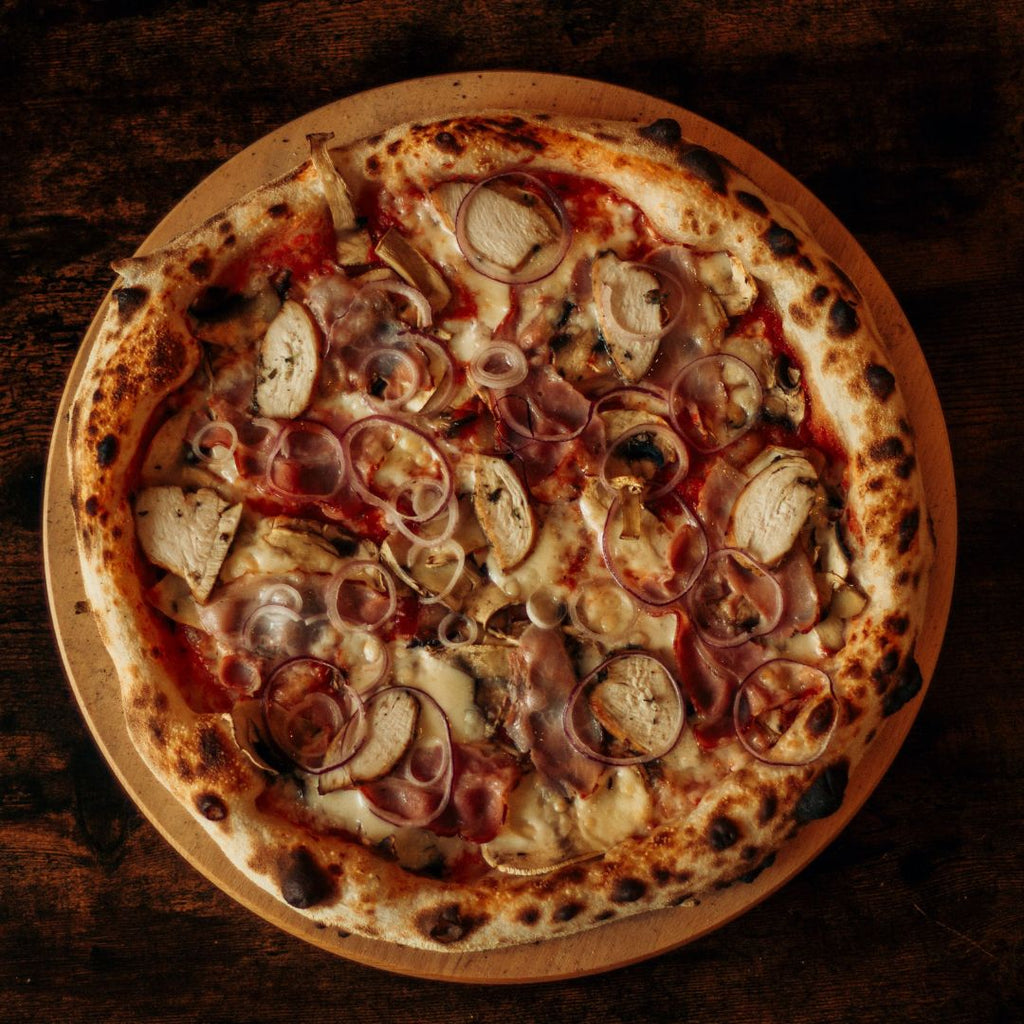 Pizza cu crusta rumenită gătită la cuptorul pe lemne